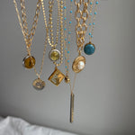 Close-up of a handcrafted repurposed vintage green YSL pendant necklace on a gold-filled, high-shine chain. Featuring an authentic Saint Laurent charm, this unique piece merges timeless luxury with modern elegance, perfect for everyday wear or layering.