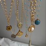 Close-up of a handcrafted repurposed vintage green YSL louis vuitton and givenchy pendant necklace on a gold-filled, high-shine chain. Featuring an authentic Saint Laurent charm, this unique piece merges timeless luxury with modern elegance, perfect for everyday wear or layering.