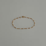 Dainty beaded bracelet crafted from gold filled satellite enamel chain.