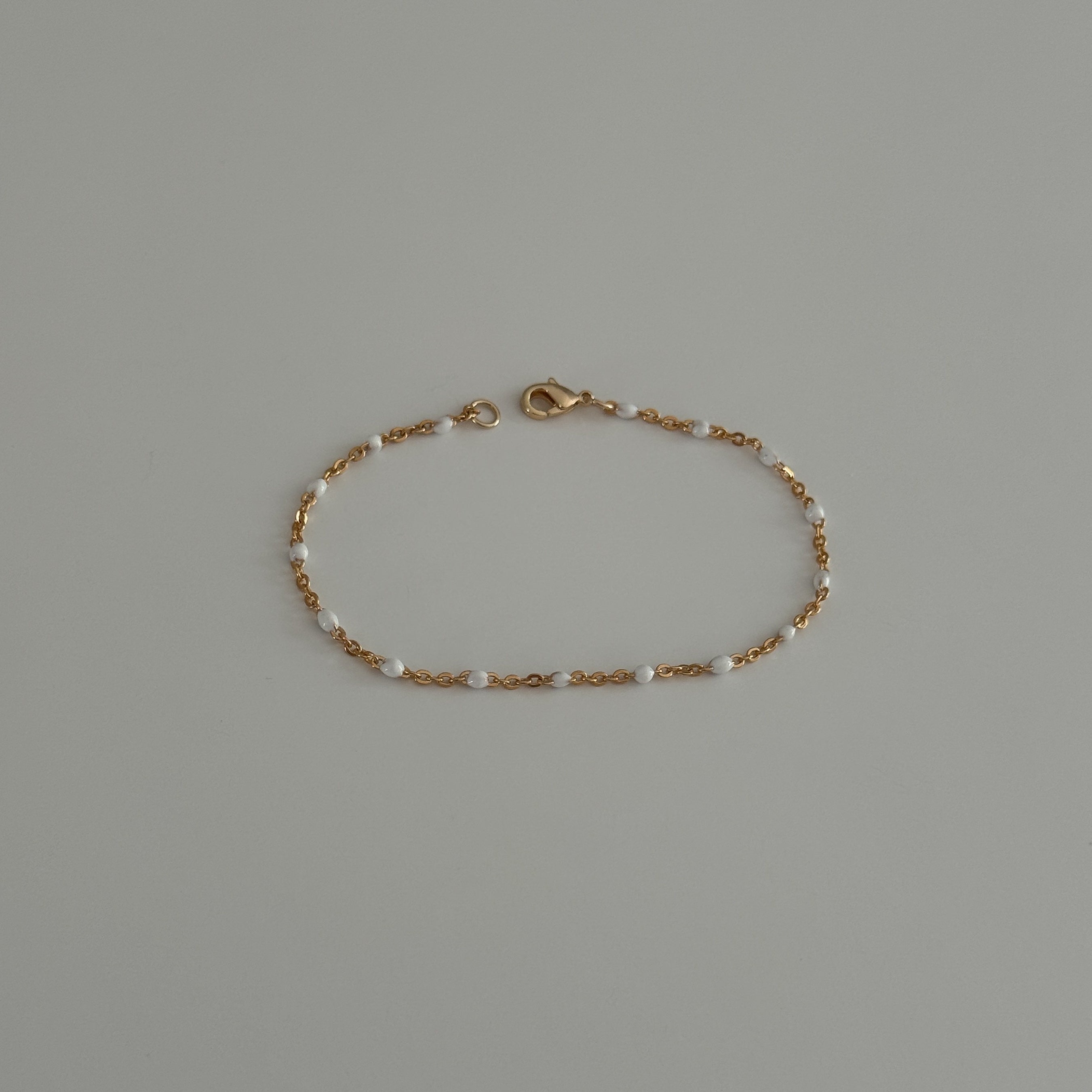 Dainty beaded bracelet crafted from gold filled satellite enamel chain.