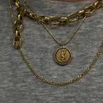vintage gold ysl monogram logo pendant necklace on body
