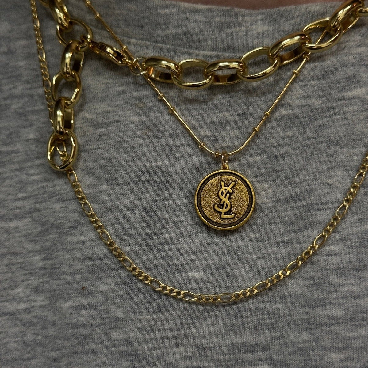 vintage gold ysl monogram logo pendant necklace on body
