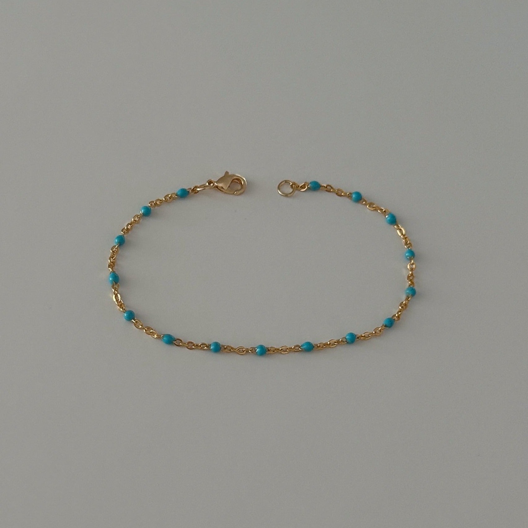 Dainty beaded bracelet crafted from gold filled satellite enamel chain.